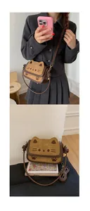 Detail view of a brown suede cat-shaped crossbody bag with embroidered paw prints