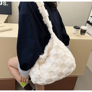 Detail view of large white plush checkerboard tote bag worn as a casual crossbody bag