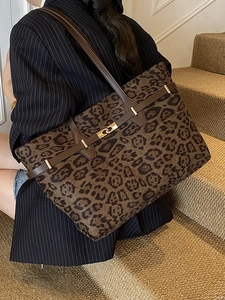 Chic leopard print large tote bag with dark brown handles and golden lock shown on shoulder