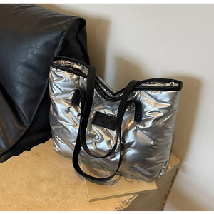 Détail du sac cabas matelassé argenté avec écusson mode noir et finition métallique