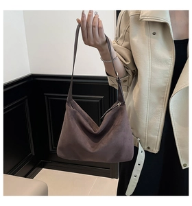 Close-up of suede hobo bag texture and slim shoulder strap on dark brown tote bag