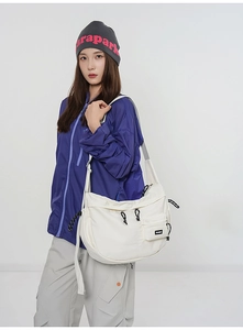 Détail d'un sac messager en toile blanche avec des éléments de cordon décoratifs