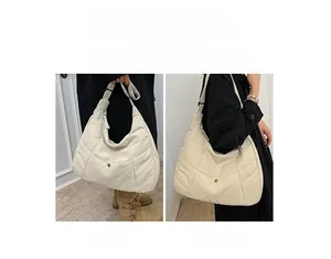 Détail d'un sac matelassé beige montrant les styles de porté main et porté épaule