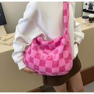 Close-up of pink checkered plush tote bag with soft faux fur texture in a cozy setting