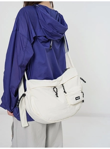 Détail du sac bandoulière en nylon blanc avec design multi-poches et sangle réglable