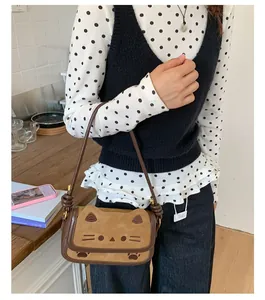 Close-up of brown cat-shaped shoulder bag featuring cute embroidered cat face details