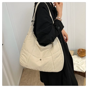 Détail du sac cabas en nylon matelassé avec grande capacité et poche avant à bouton-pression
