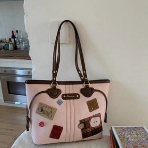 Detail of light pink tote bag featuring cute Puppy embroidery and Aimaier metal logo