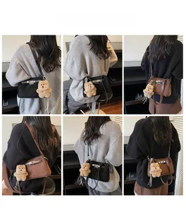 Detail view of mini retro crossbody bags in black and coffee with plush bear charms