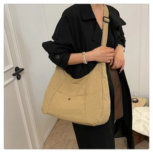 Détail du sac bandoulière demi-lune kaki avec sangle réglable et poche à bouton métallique
