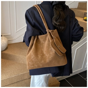 Brown faux suede tote bag with matching coin purse shown on model in a stylish setting
