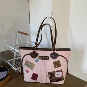 Detail of pink tote bag with puppy patch and vintage brown leather trim accents
