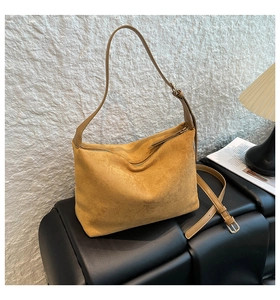 Detail view of mustard yellow suede hobo bag with gold hardware and dual straps