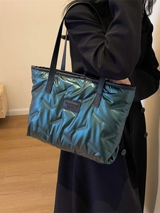Sac fourre-tout matelassé vert métallisé avec anses en cuir noir et étiquette mode