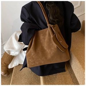 Close-up of brown matte tote bag with matching zippered pouch and minimalist shoulder strap