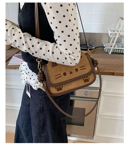 Detail of cute cat-themed crossbody bag featuring cat ears and paw print patterns
