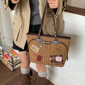Detail view of khaki suede tote bag with cartoon puppy and flower embroidery patches