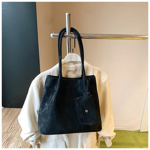 Detail of matte black tote bag with matching mini pouch hanging on a display rack