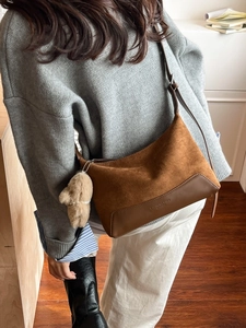 Vintage brown leopard print shoulder bag with plush bear charm worn by a model