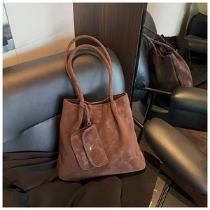 Brown vintage suede tote bag with detachable pouch on a leather seat detail