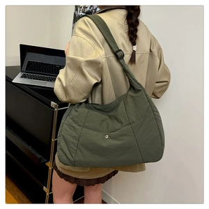 Détail du sac bandoulière en nylon vert olive avec sangle réglable et fermoir métallique aimanté