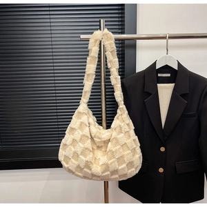 Detail of cream plush checkerboard tote bag with embossed texture on metal hanger