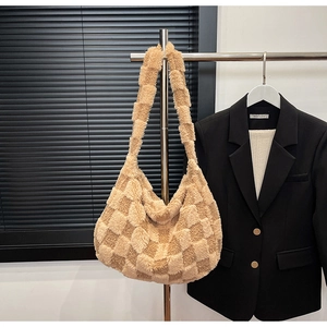 Detail of soft khaki plush tote bag with checkered pattern on a display hanger