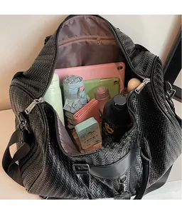 Detail view of woven travel bag with spacious interior for laptop and essentials