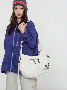 Grand sac bandoulière en toile blanche avec poche frontale zippée et cordons tressés