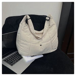 Détail du sac fourre-tout en nylon matelassé crème avec bandoulière réglable