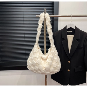 Close-up of fluffy white faux fur texture and checkered pattern on large commute bag