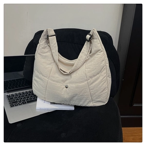 Détail du sac bandoulière matelassé avec large sangle et boucle de réglage noire