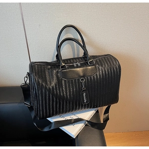 Detail showing black woven textured synthetic leather with silver metal zipper on travel bag
