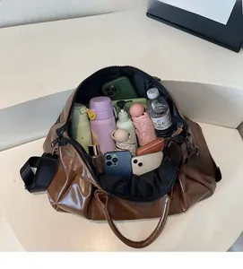 Vue détaillée du dessus montrant l'intérieur spacieux d'un grand sac de voyage en similicuir
