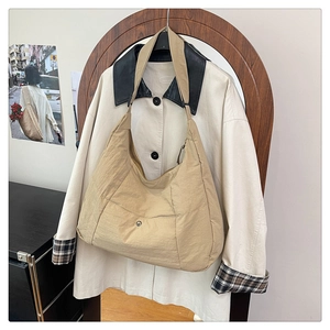 Détail du sac hobo croissant en nylon beige avec poche à pression et fermeture éclair