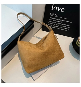 Detail view of the vintage caramel suede hobo bag with adjustable strap in a lifestyle setting
