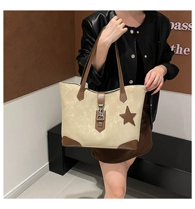 Detail der Retro-Tragetasche in Beige und Braun mit Stern-Patch und Schnalle