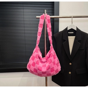 Detail of plush checkerboard hobo bag in pink tones with soft faux fur texture
