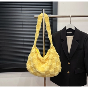 Close-up of a large yellow checkered plush tote bag with a matching shoulder strap