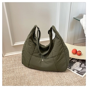 Gros plan détaillé du sac cabas matelassé vert olive avec bandoulière et poche à bouton-pression