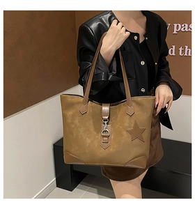Detail der braunen Wildleder-Tragetasche mit Sternen-Applikation und Vintage-Metallschnalle