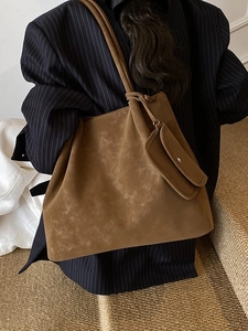 Large brown suede tote bag with matching coin purse shown on a model in minimalist style