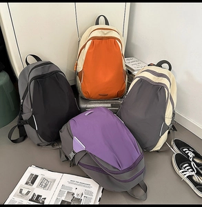 Multiple colorblock nylon backpacks displayed with luggage for travel and campus style