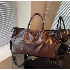 Détail macro du sac de voyage en cuir PU marron foncé avec fermetures éclair et anses