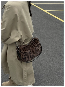 Détail du sac à bandoulière en peluche léopard avec chaîne argentée et sangle en cuir