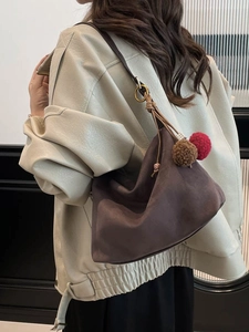 Retro faux suede hobo bag in dark brown with colorful pompom charm on a model