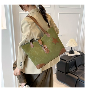 Nahaufnahme der olivgrünen Wildleder-Tote-Bag mit Lederstern-Patch und Metallschnalle