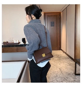 Détail du sac à main en cuir marron foncé avec fermoir carré en métal doré vintage