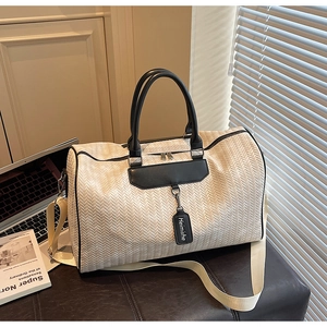 Detail of herringbone travel bag with leather handles and wide adjustable shoulder strap