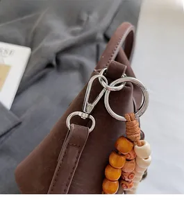 Detail of premium silver-tone hardware and decorative wooden beads on dark brown leather bag